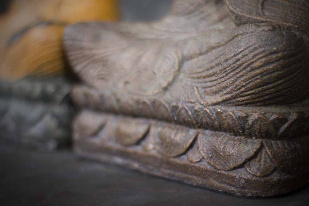 Zittende Buddha met handen in gebed